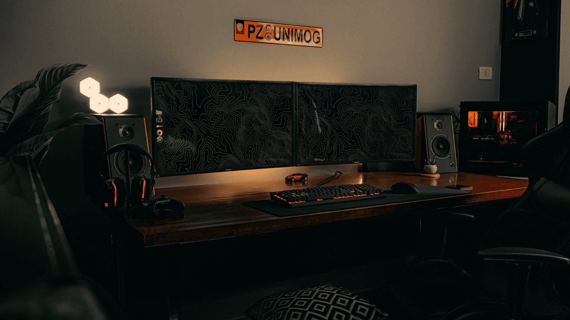 Dual-monitor workstation lit by warm accent lighting